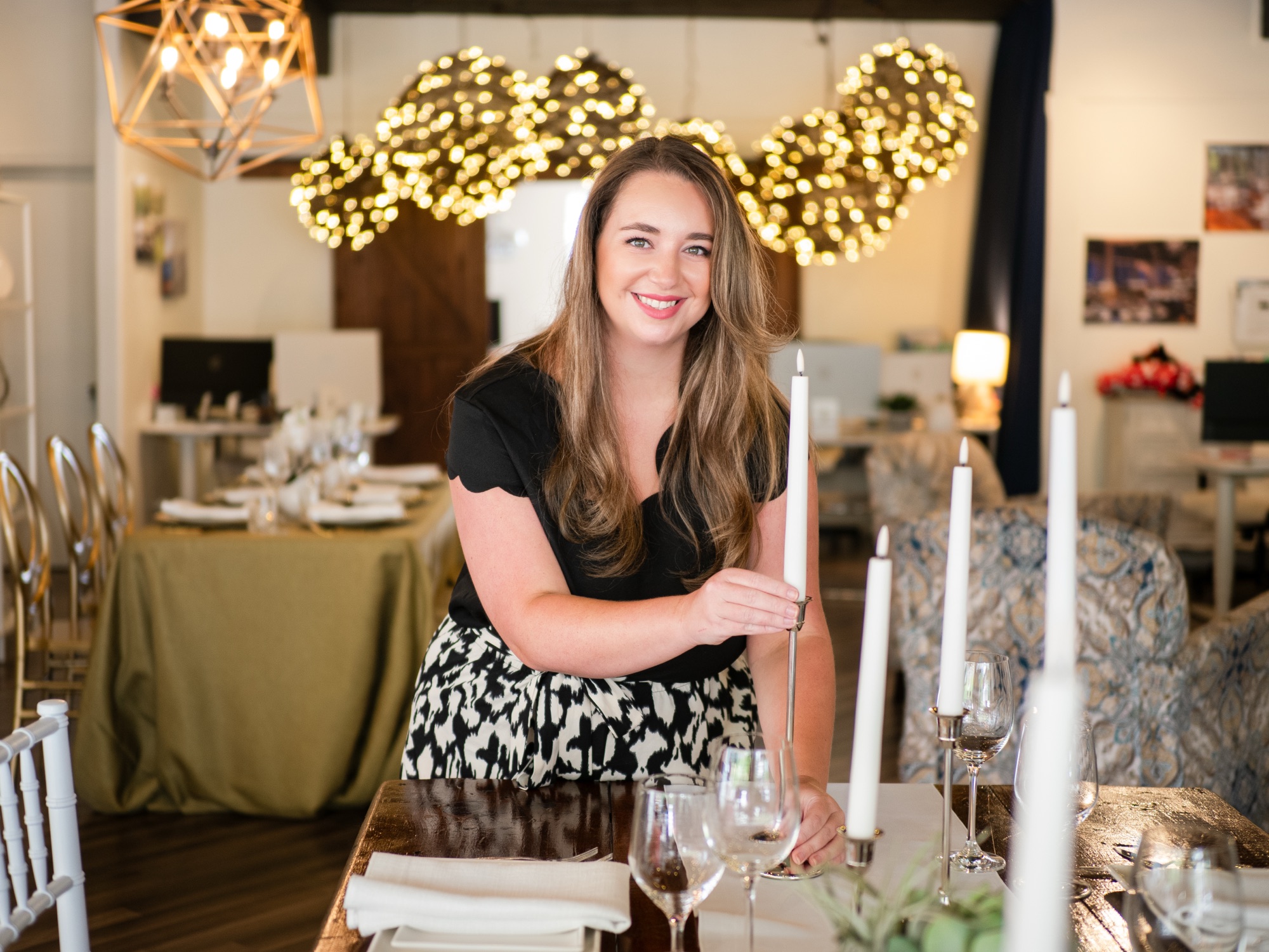 Event planner styling a beautifully set table with candles and glassware